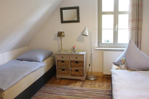 a bedroom with two beds and a lamp and a window at landhaus rosmarin in Oschersleben