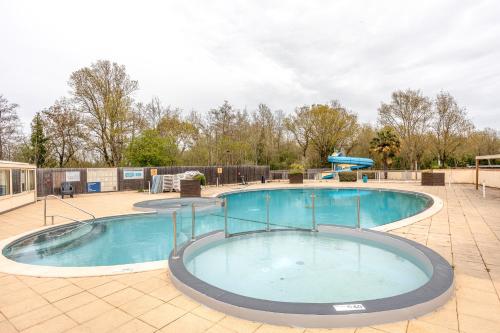une grande piscine sur un patio carrelé dans l'établissement Mobilhome - piscines - terrasse, à Angles