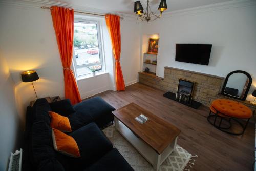 a living room with a couch and a fireplace at Spacious 3 Bed Terrace with Large Kitchen Diner in Hawick