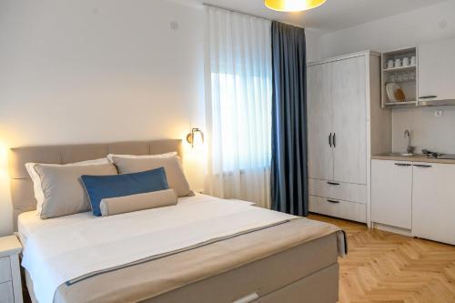 a bedroom with a large bed with a blue pillow on it at Vila sa bazenom Vrnjačka Idila in Vrnjačka Banja