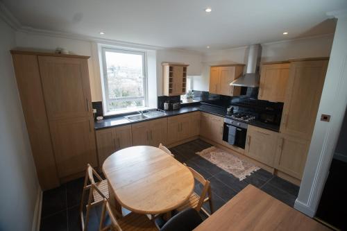 a kitchen with a wooden table and a table and chairs at Spacious 3 Bed Terrace with Large Kitchen Diner in Hawick