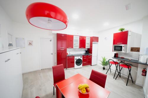 a kitchen with red cabinets and a red table and chairs at En Madrid, amplio, especial grupos o familias in Leganés