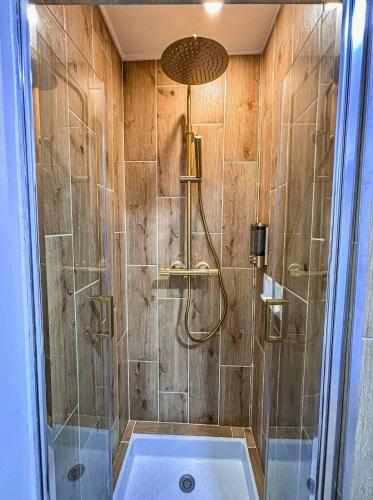 a bathroom with a shower with a tub at Sous les toits de la Digue in Verdun