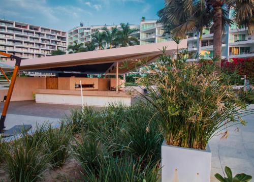 a view of a building with palm trees and plants at Suites at Aria Luxury Double Suite on the Pacific Coast in Nuevo Vallarta 