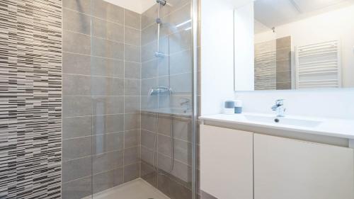 une salle de bain avec une douche, un lavabo et un miroir dans l'établissement La Dune N76 - VILLA 2P6, à Sérignan