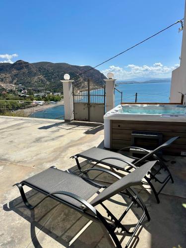 two lounge chairs and a swimming pool on a patio at Irini Panorama in Agia Galini