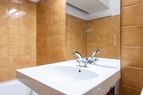 a bathroom with a sink and a mirror at Appartement Aime 2000 in Mâcot La Plagne