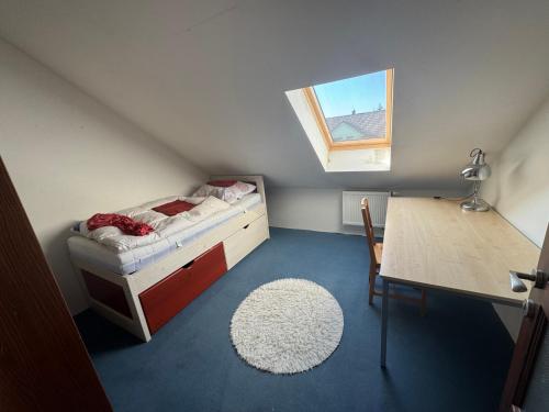a small attic room with a bed and a desk at Domov pro 8 hostů ve městě Karlovy Vary in Karlovy Vary
