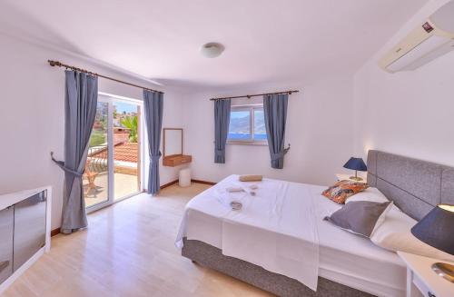 a bedroom with a bed and a large window at Villa Nane in Kaş