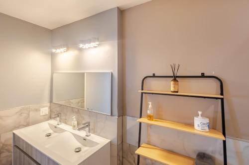a bathroom with a sink and a mirror at Stylish SOHO-Inspired Loft, 15 Min to NYC Times Square in Union City