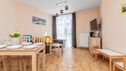 a living room with a table and a dining room at Bursztynowe Osiedle Jantar, Sun & Snow in Jantar