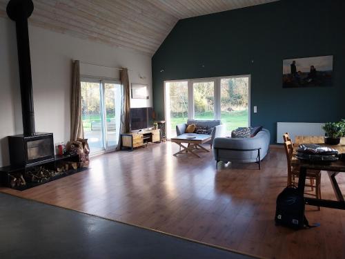 un salon avec un canapé et une cheminée dans l'établissement Maison très agréable, à Pleyber-Christ