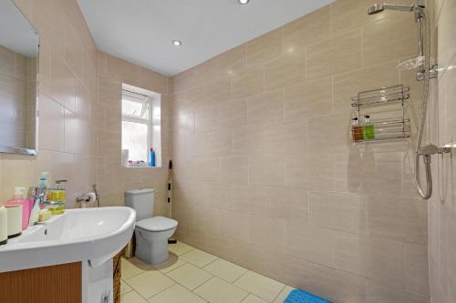 a bathroom with a sink and a toilet at Elegant 5 Bedroom and 3 Bathroom Home in St Annes in Stanwell