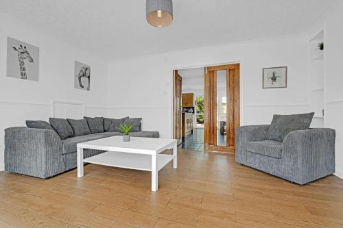 a living room with two couches and a coffee table at Elegant 5 Bedroom and 3 Bathroom Home in St Annes in Stanwell