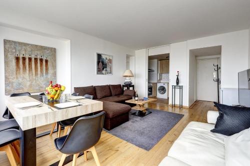un salon avec un canapé et une table dans l'établissement 5019 Suite Pouey - Apartment near La Défense, à Puteaux