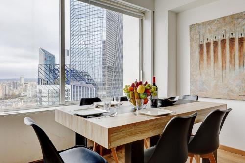 une salle à manger avec une table et des chaises et une grande fenêtre dans l'établissement 5019 Suite Pouey - Apartment near La Défense, à Puteaux