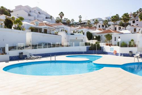 ein Swimmingpool vor einer Villa in der Unterkunft Home2Book Stunning Views Bungalow Costa Adeje in Adeje
