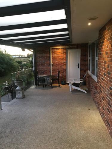 a patio with chairs and a brick wall at Robyn's Nest in Sentry Hill
