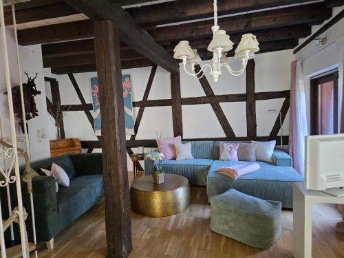a living room with blue couches and a chandelier at Chalet Madeleine - 160 qm Ferienhaus in Baden-Baden
