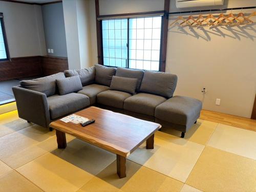 a living room with a couch and a coffee table at Nozawa Onsen Azegamikan in Nozawa Onsen