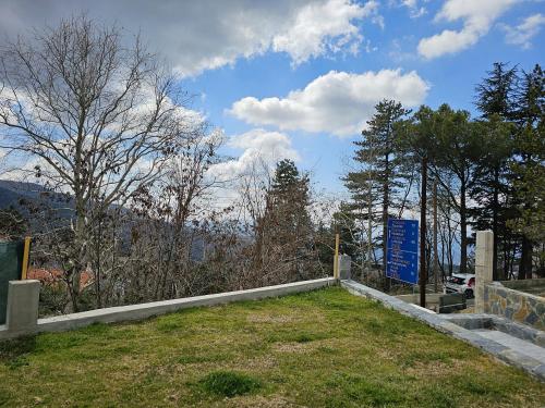 a cemetery with a blue sign in the grass at Ride&Rest by Zabike in Prodromos