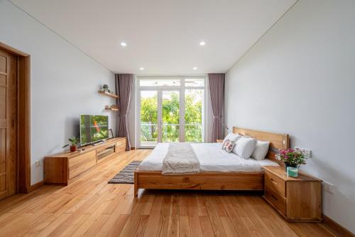 a bedroom with a bed and a large window at Thao Dien Serenity Villa in Ho Chi Minh City