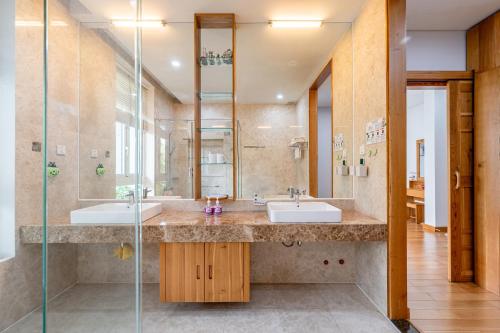 a bathroom with two sinks and a glass shower at Thao Dien Serenity Villa in Ho Chi Minh City
