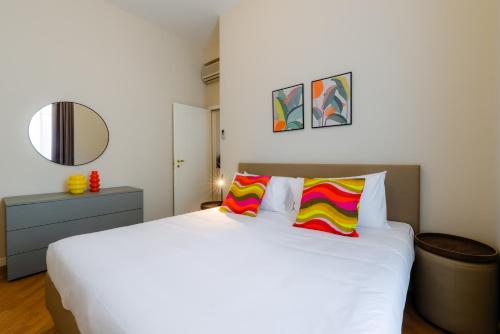 a bedroom with a large white bed with two colorful pillows at R Oleandro House in Como
