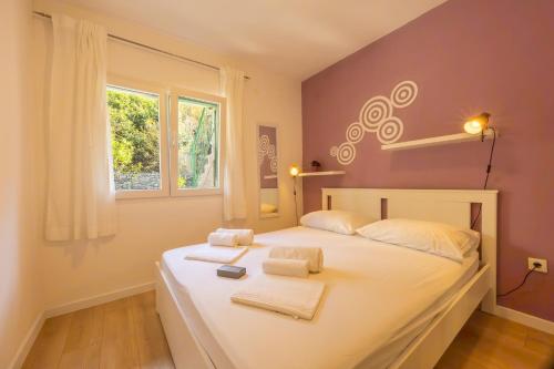 a bedroom with a bed with towels on it at Apartments Kržanić in Podgora