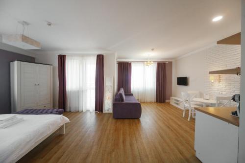 a bedroom with a bed and a kitchen and a living room at BonApart Delux in Lviv