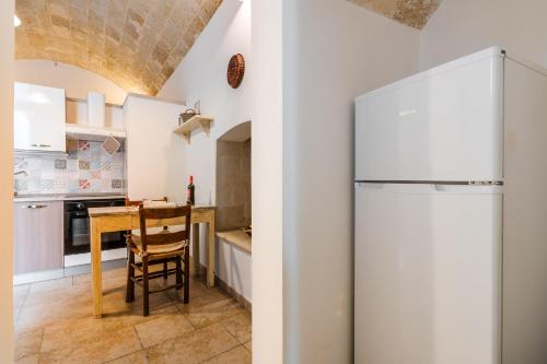 a kitchen with a white refrigerator and a table at Luxury 12 in Tuglie