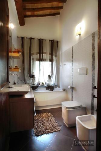 a bathroom with a tub and a toilet and a sink at Chianti Luxury villa con piscina e idromassaggio in San Donnino