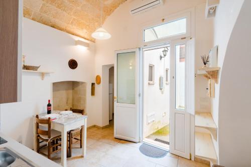 a kitchen and dining room with a table and a window at Luxury 12 in Tuglie