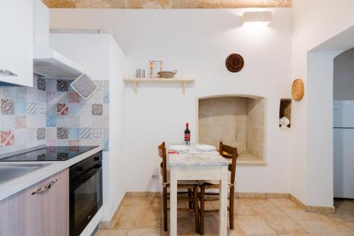 a kitchen with a small table and a stove at Luxury 12 in Tuglie