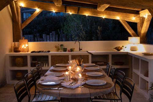 a dining room table with chairs and lights on it at La Grange de Fer - Maison de caractère piscine privée in Saint-Ferréol-Trente-Pas