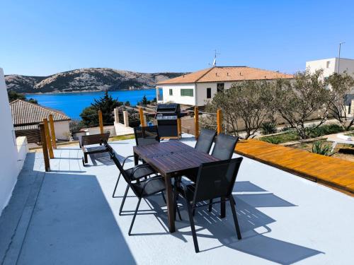 einen Tisch und Stühle auf einer Terrasse mit Blick auf das Wasser in der Unterkunft Holiday Home Jan in Stara Novalja