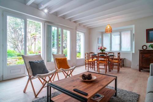 un salon avec une table et des chaises dans l'établissement Ker-Laco - Plage à 200m proche sentier GR24, à Saint-Armel