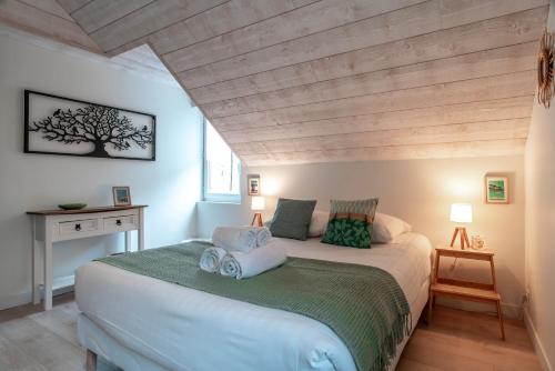 une chambre avec un grand lit avec un plafond en bois dans l'établissement Ker-Laco - Plage à 200m proche sentier GR24, à Saint-Armel