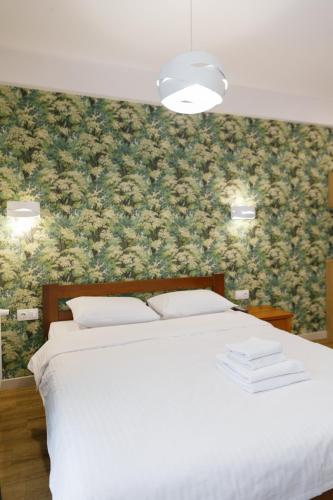 a bedroom with a white bed with a floral wallpaper at BonApart Delux in Lviv