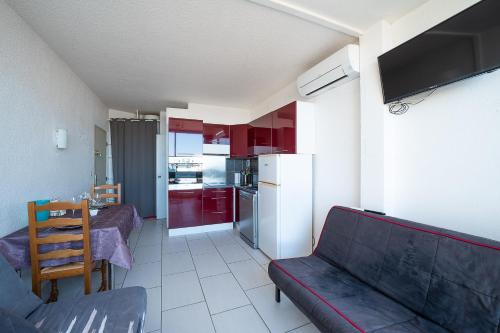un salon avec un canapé et une cuisine dans l'établissement Pivoine - Vue mer plage à 100m proche Espagne, à Saint-Cyprien