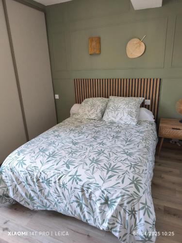 une chambre avec un lit avec une couette bleue et blanche dans l'établissement Maison catalane rénovée, à Montescot