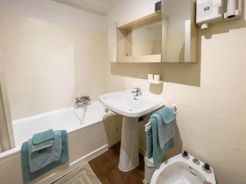 une salle de bain blanche avec un lavabo et des toilettes dans l'établissement Azur Soleil, à Juan-les-Pins