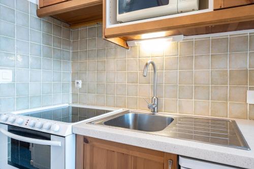 a kitchen with a sink and a stove at Les Bouquetins A in La Rosière