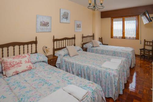 1 Schlafzimmer mit 3 Betten und einem Fenster in der Unterkunft El Arco de Villahoz in Villahoz