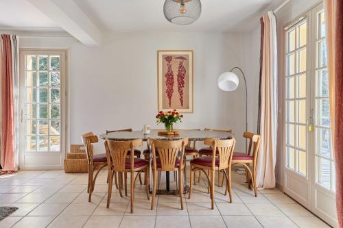 une salle à manger avec une table et des chaises dans l'établissement Le Cottage de la Fontaine Ruante - Grand Jardin, à Saint-Gatien-des-Bois