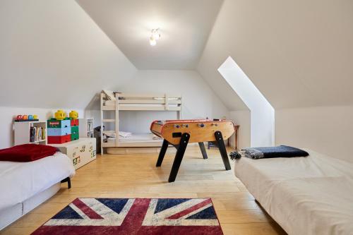 Cette chambre mansardée comprend une table et un lit. dans l'établissement Le Cottage de la Fontaine Ruante - Grand Jardin, à Saint-Gatien-des-Bois
