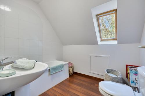 une salle de bain blanche avec un lavabo et des toilettes dans l'établissement Le Cottage de la Fontaine Ruante - Grand Jardin, à Saint-Gatien-des-Bois