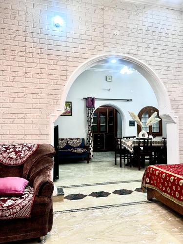 a living room with a brick wall and an archway at Aanandit aashiyana - A Blissful Place in Dehradun