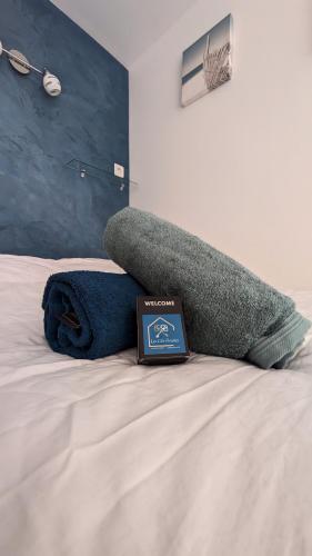 un livre assis au-dessus d'un lit dans l'établissement L'Ecrin Bleu, Studio lumineux , Wifi & parking, à Villers-sur-Mer