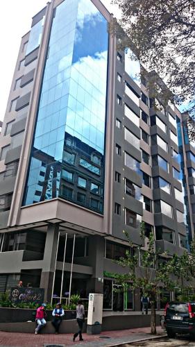 a large building with people walking in front of it at Misuitehotel La Carolina Quito in Quito